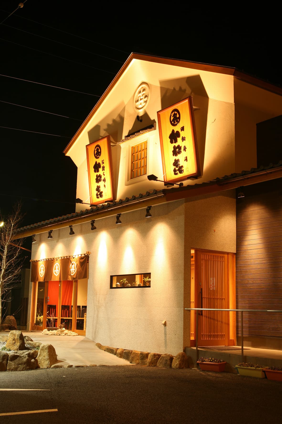 ライトアップされたかね㐂石岡店の外観